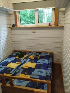 um pequeno quarto com uma cama no canto em Forest Hut em Bigauņciems