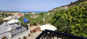 a balcony with tables and umbrellas on a hill at Anna Studio and Apartments in Tsilivi