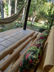 a hammock with a seat on a deck with trees at Repousada Sana in Sana