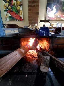 a stove with a pot on top of a fire at Repousada Sana in Sana