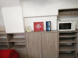 a cabinet with a microwave and a tv on it at Freya in Lesce