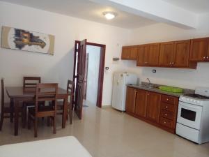 cocina y comedor con mesa y nevera en Private Apartment in Caribe Dominicus 3 SOLO ADULTOS en La Laguna