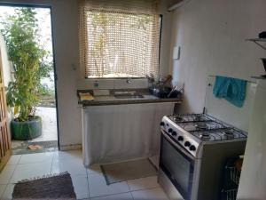 a kitchen with a stove and a sink and a window at Casa da Dona Dita in Paraty