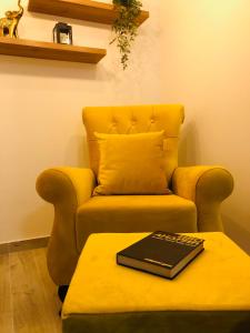 uma sala de estar com um sofá com um livro sobre uma mesa em Masha Apartment em Divčibare