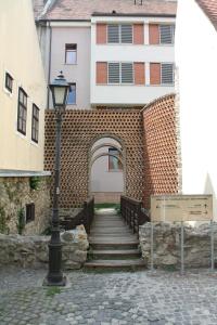 a brick building with a staircase and a street light at Zwinger Apartman in Sopron