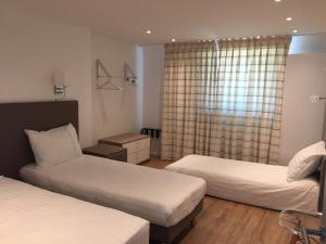 pokój hotelowy z 2 łóżkami i oknem w obiekcie Shelter-rooms w mieście Buysinghen