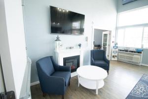 a living room with two chairs and a table and a fireplace at The Baywatch Resort in Traverse City