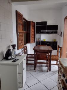 CASA NA PRAIA TEMPORADA في بيرويبي: مطبخ مع طاولة وكراسي في غرفة