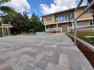une terrasse en face d'un bâtiment avec une piscine dans l'établissement FINCA CORENAS, à La Cumbre