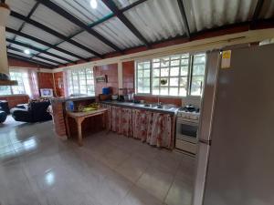 eine Küche mit einem Kühlschrank und einem Tisch darin in der Unterkunft FINCA CORENAS in La Cumbre