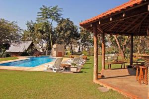 a swimming pool with lounge chairs and a pavilion at Pousada Di Luna in Bonito