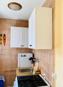 a kitchen with white cabinets and a stove top oven at Sunny Parkside Apartment in Bar