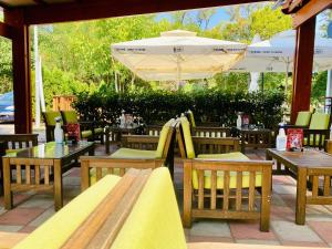a patio with tables and chairs and an umbrella at Sunny Parkside Apartment in Bar
