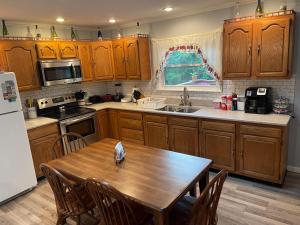 a kitchen with wooden cabinets and a wooden table at Branson Country B&B in Hermann