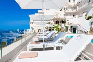 a row of white lounge chairs on the roof of a building at Grand Hotel Tritone in Praiano