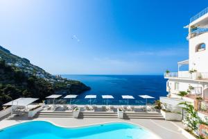 a view of a hotel with a swimming pool and the ocean at Grand Hotel Tritone in Praiano