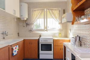 a kitchen with a white stove and a window at Casa del Dorado Playa cambrils in Cambrils