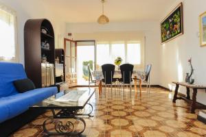 a living room with a blue couch and a table and chairs at Casa del Dorado Playa cambrils in Cambrils