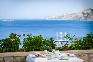 a table with food and a view of the ocean at Grand Hotel Tritone in Praiano