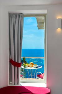 a window with a table with a view of the ocean at Grand Hotel Tritone in Praiano