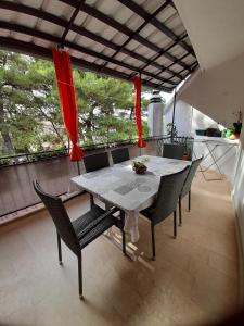 a dining room with a table and chairs on a balcony at HOUSE-APARTMENTS ELA -MIRCA- FAMILY HOLIDAY in Mirce