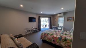um quarto com uma cama, um sofá e uma janela em Hidden Gem in Oaklands em Napier