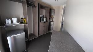 a kitchen with a stainless steel refrigerator and cabinets at Hidden Gem in Oaklands in Napier