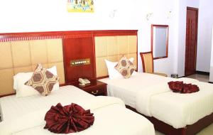 a hotel room with two beds with bows on them at RUNGWE HOTEL in Dar es Salaam