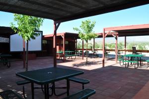 a patio with tables and chairs and trees at K7 Bed and Breakfast in Pahrump
