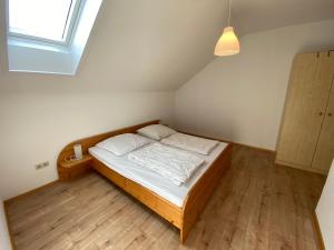 a bedroom with a wooden bed in a attic at Ferienhaus an der Westernstadt in Eging in Eging