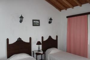 een slaapkamer met 2 bedden en een rood gordijn bij Quinta Do Canavial in Velas