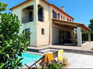 une maison avec une piscine en face de celle-ci dans l'établissement Le Petit Bali Spacieuse Villa pour 8 avec Piscine, à Saint Cyprien Plage