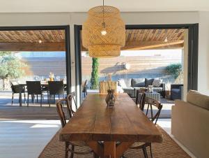 a dining room with a wooden table and chairs at Le Petit Bali Spacieuse Villa pour 8 avec Piscine in Saint Cyprien Plage