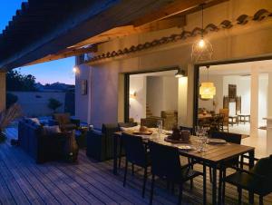 een terras met een tafel en stoelen op een dek bij Le Petit Bali Spacieuse Villa pour 8 avec Piscine in Saint Cyprien Plage