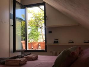 sypialnia z łóżkiem i dużym oknem w obiekcie Up To Sky - Appartment With Terrace w Mediolanie
