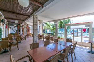 un restaurant vide avec des tables et des chaises en bois dans l'établissement Apartments Klaric, à Krilo