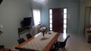 a living room with a table with a vase of flowers on it at Casa de verano con Pileta, Quincho y Garage Parque Luro MDP in Mar del Plata