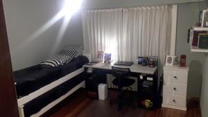 a bedroom with a bed and a desk with a desk at Casa de verano con Pileta, Quincho y Garage Parque Luro MDP in Mar del Plata +5 photos