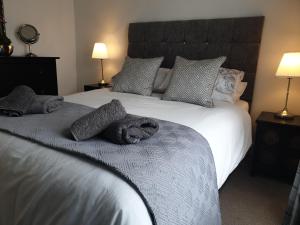 sypialnia z dużym białym łóżkiem z poduszkami w obiekcie Kingfisher cottage w mieście Worthing