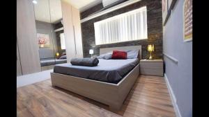 een slaapkamer met een bed met een bakstenen muur bij Riviera Penthouse in Marsaskala +8 foto's