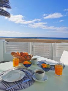 a table with a basket of bread and cups of coffee at Luxury Apartment On The Beach in Playa Honda