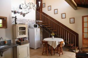 uma cozinha com uma mesa e uma escada com um frigorífico em Chalé do Lago em Araxá