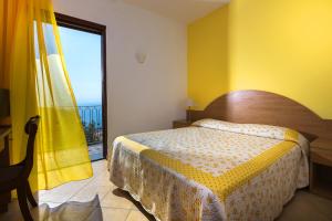 - une chambre avec un lit et une grande fenêtre dans l'établissement L'Ulivo Resort, à Vico Equense