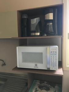 a microwave sitting on a shelf in a kitchen at Casa no Vale dos Vinhedos in Bento Gonçalves