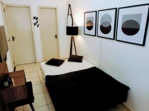 um quarto com uma cama e uma mesa e quadros na parede em Residencial Catarina em Florianópolis