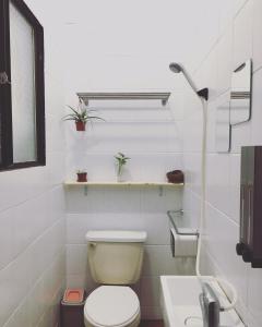 a white bathroom with a toilet and a sink at Page Surfing Inn in Donghe