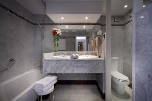 
a bathroom with a tub, toilet and sink at Abades Benacazon in Benacazón
