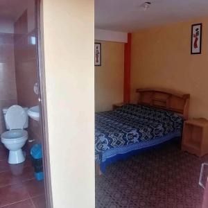 1 dormitorio con 1 cama y baño con aseo en Hostal Puerto Alegre, en Copacabana