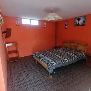 a bedroom with a bed in a room with orange walls at Hostal Puerto Alegre in Copacabana