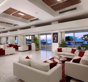 a large living room with white couches and windows at Airotel Achaia Beach in Patra